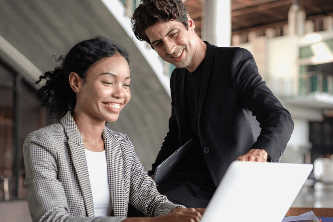 Two people working at a laptop